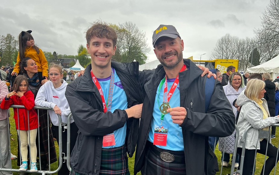 Two men are celebrating that they've walked the Kiltwalk for Ben - showing their medals