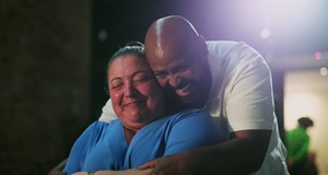 Man and woman smiling and hugging