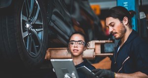 Automotive technicians working to repair automobile in motor garage