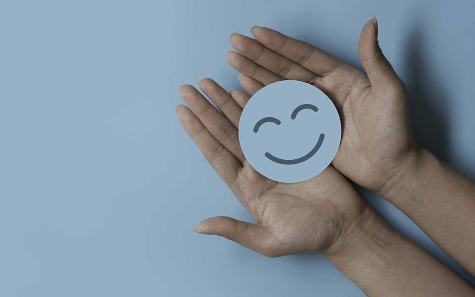 Smiling face paper circle held in two palms