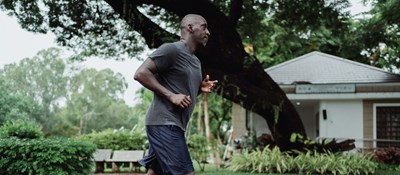 Person running down a street to boost their physical health