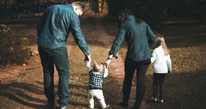 A family spending time together in nature walking down a woodland path
