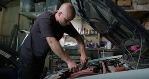 Vehicle technician working to fix a car. Work forms an important part of life and can have positive impacts on health and wellbeing 